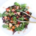 Strawberry Goat Cheese Salad in a large white serving bowl with tongs.
