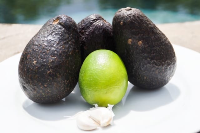 Three avocados, two cloves of garlic and one lime
