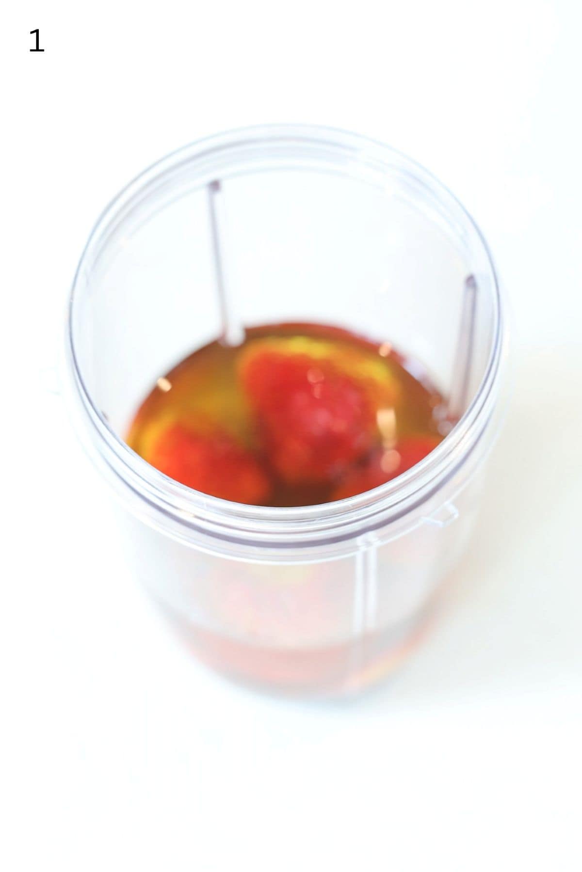 Strawberry salad dressing ingredients in a Nutri bullet blender container.