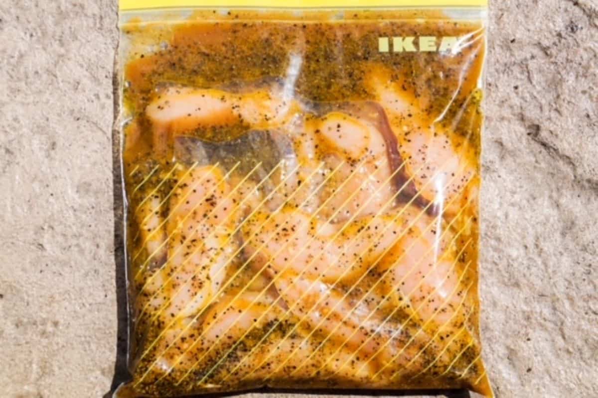 Chicken pieces marinating in a resealable bag.