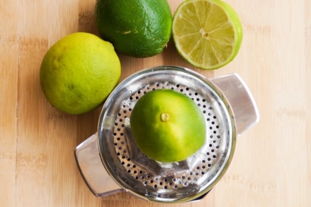 Lime on top of a stainless steel citrus juicer