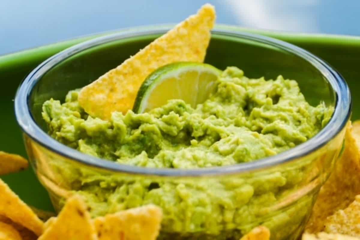 Small serving of guacamole in a bowl of chips.