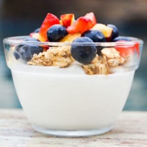 Fruit and yogurt parfait, layered, in a glass dish.