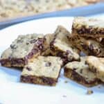 A stack of chocolate chip cookie bars on a white plate.