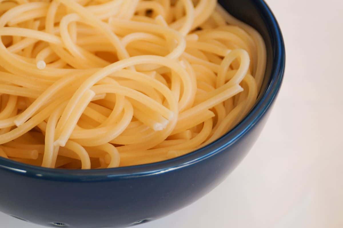 Cooked spaghetti noodles in a blue bowl