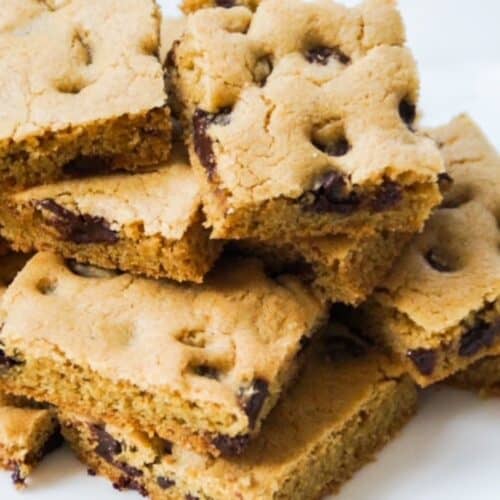 Stack of chocolate chip cookie bars on a white plate.
