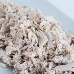 Shredded chicken on a white platter.