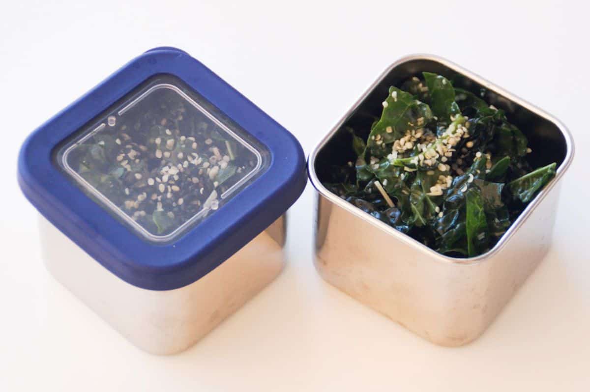 Kale salad in square stainless steel lunch containers.