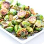 Roasted Brussels sprouts on a white rectangular shaped plate.