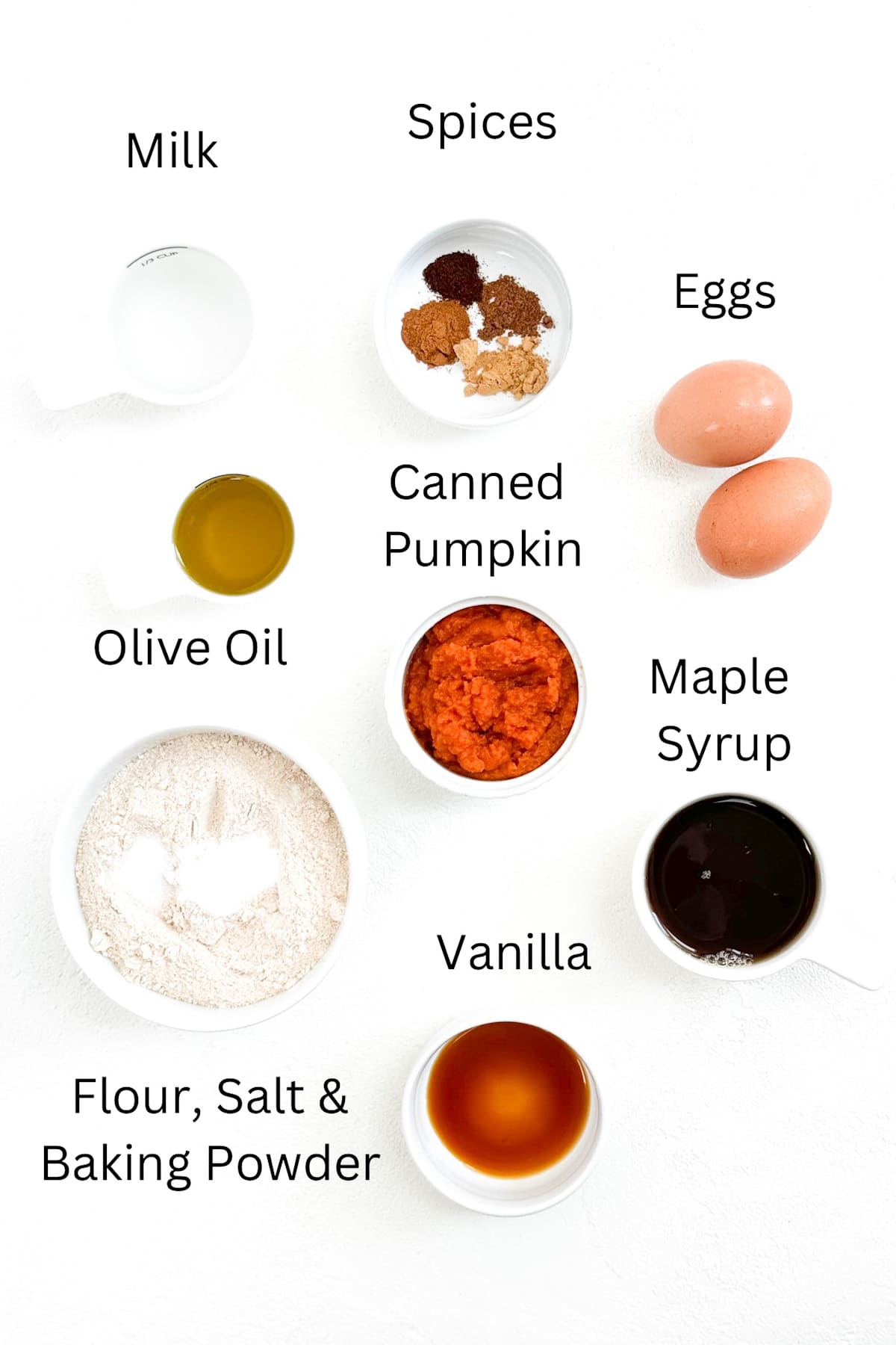 Ingredients for whole wheat pumpkin waffles labeled and placed individually on a white background.