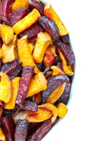 Roasted beets and sweet potatoes in a white bowl.