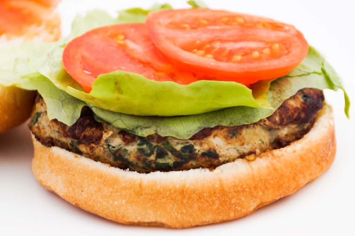 Open faced turkey burger with lettuce and tomato on a bun.