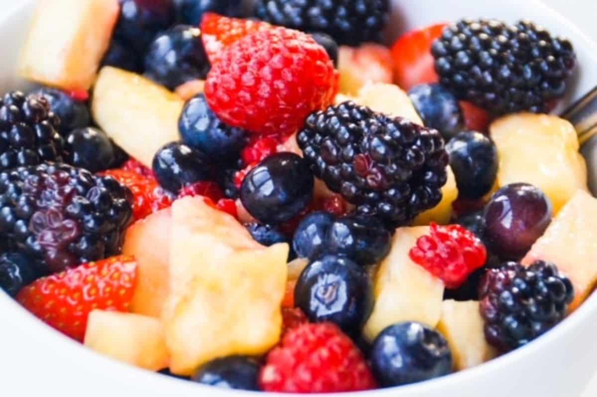 Fresh fruit salad in a white bowl.