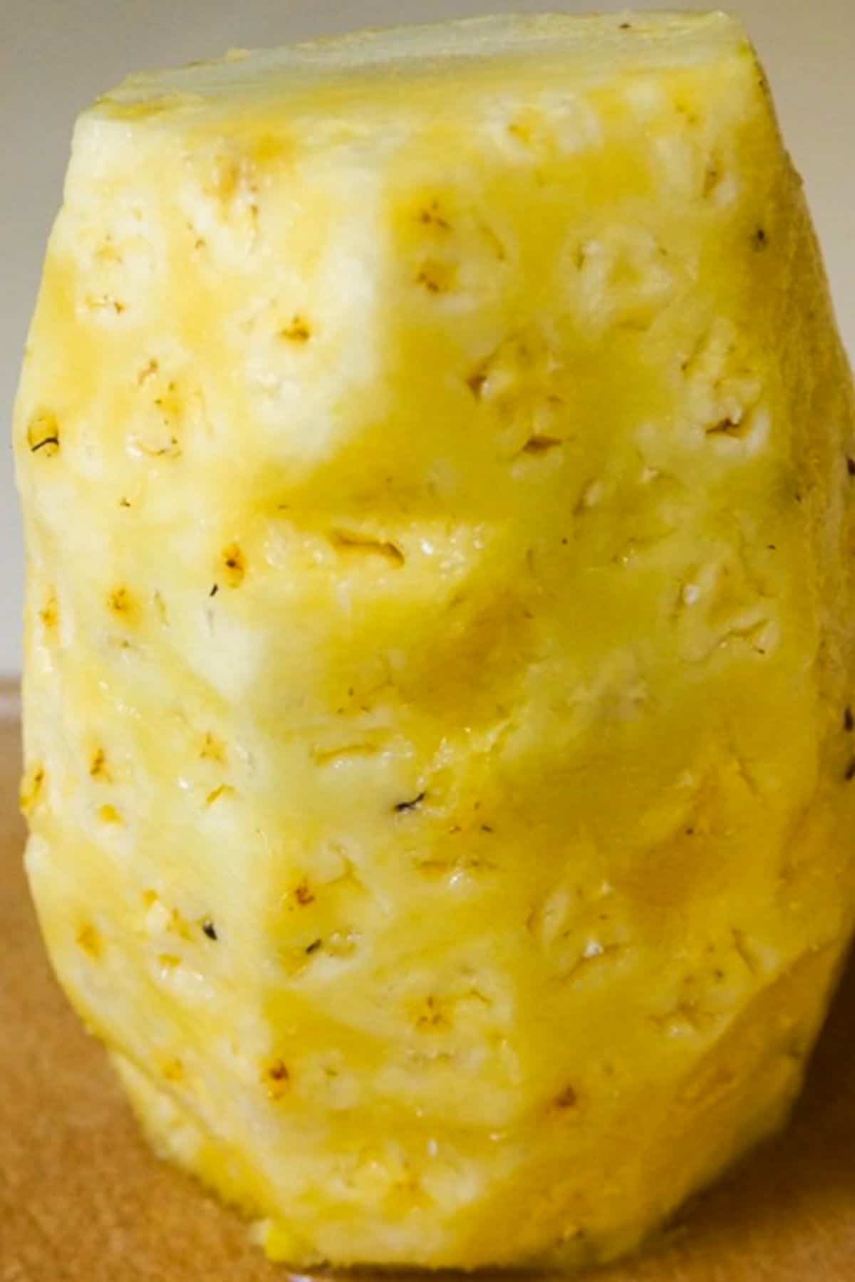 Peeled whole pineapple standing upright.