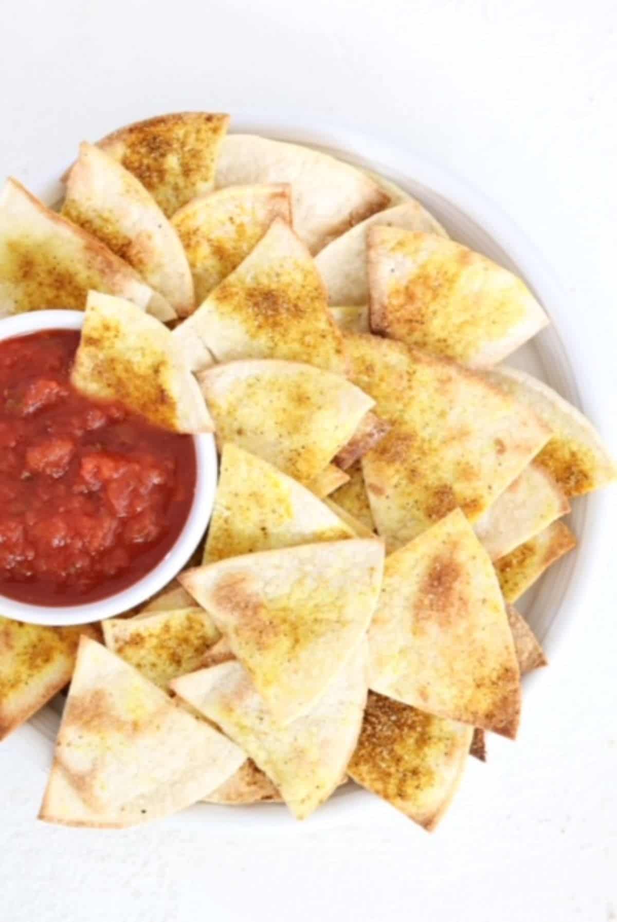 A plate of homemade tortilla chips with salsa.