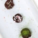 Three Vegan Chocolate Truffles on a white platter.