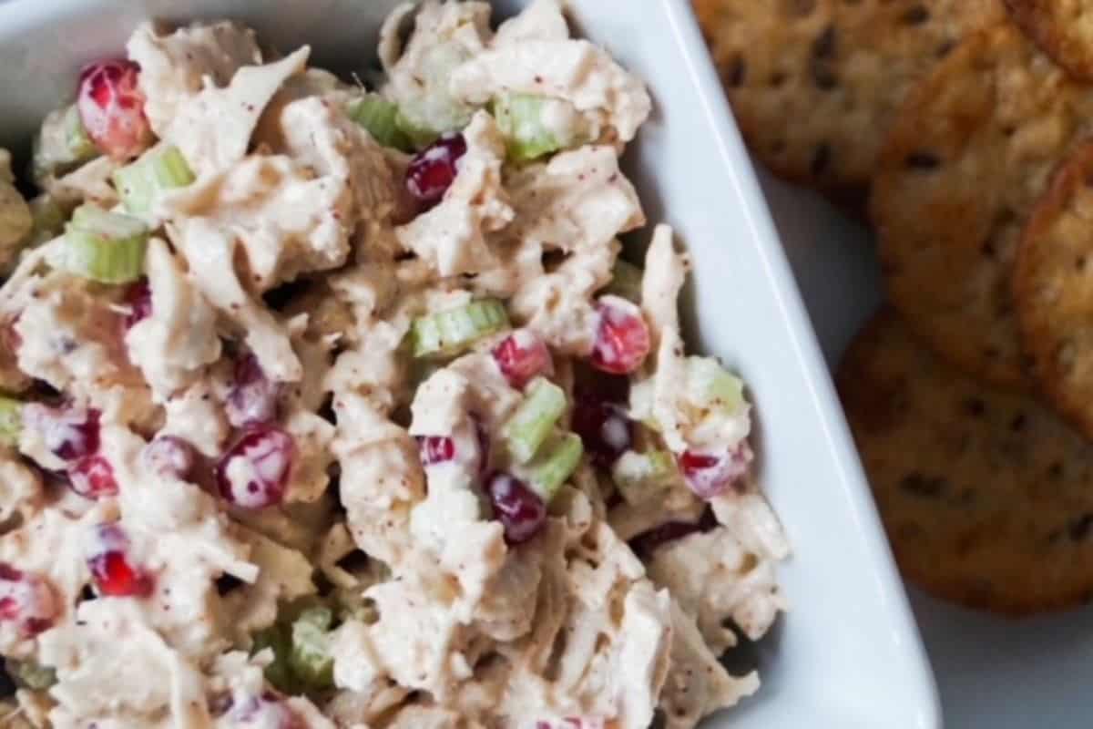 Chicken salad in a white dish with crackers to the side.