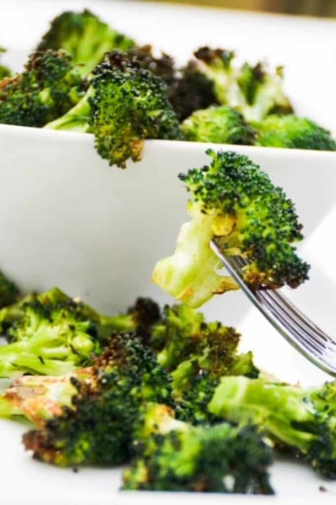 Air-fried broccoli on a plate with a fork.