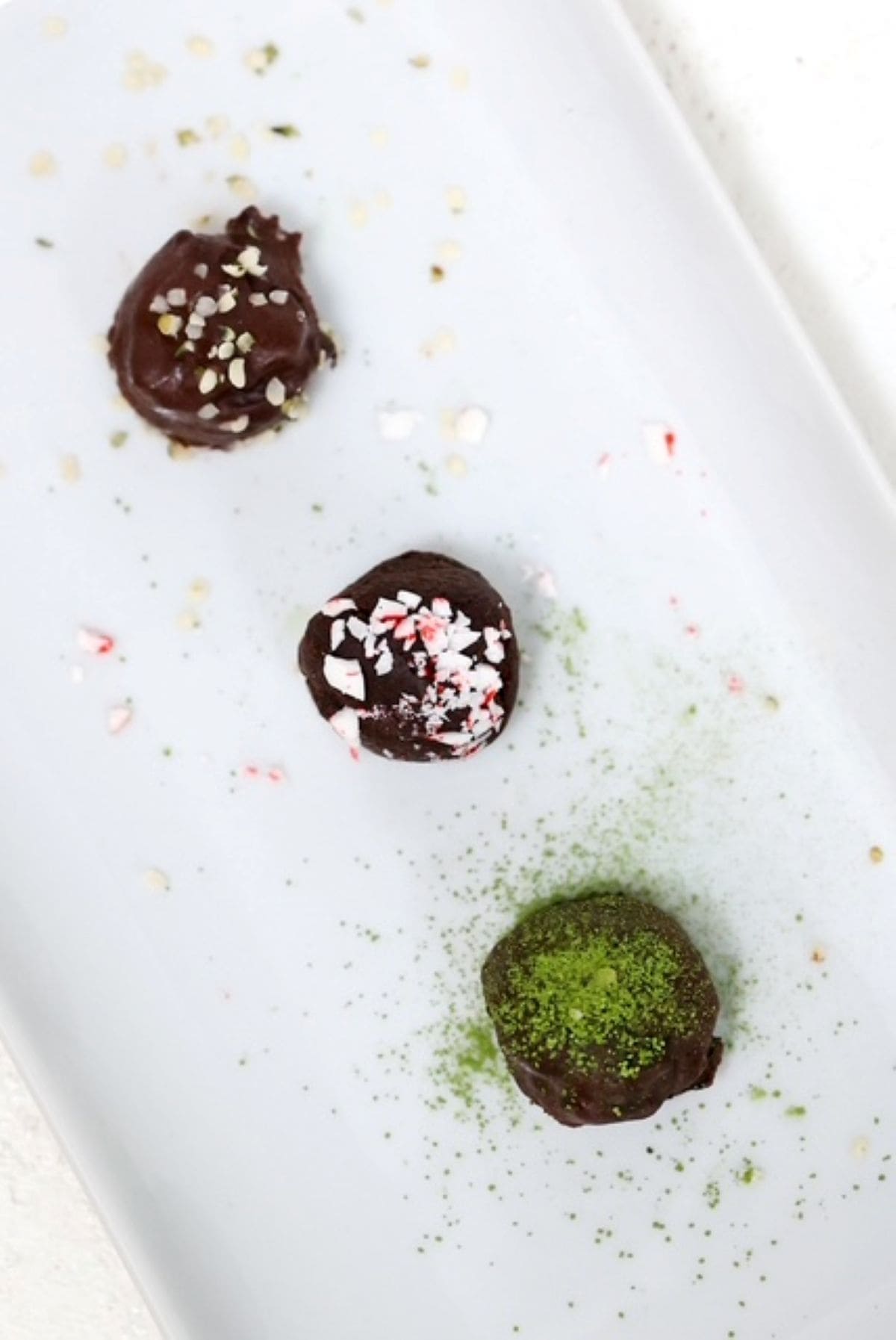 Three Vegan Chocolate Truffles on a white dish.