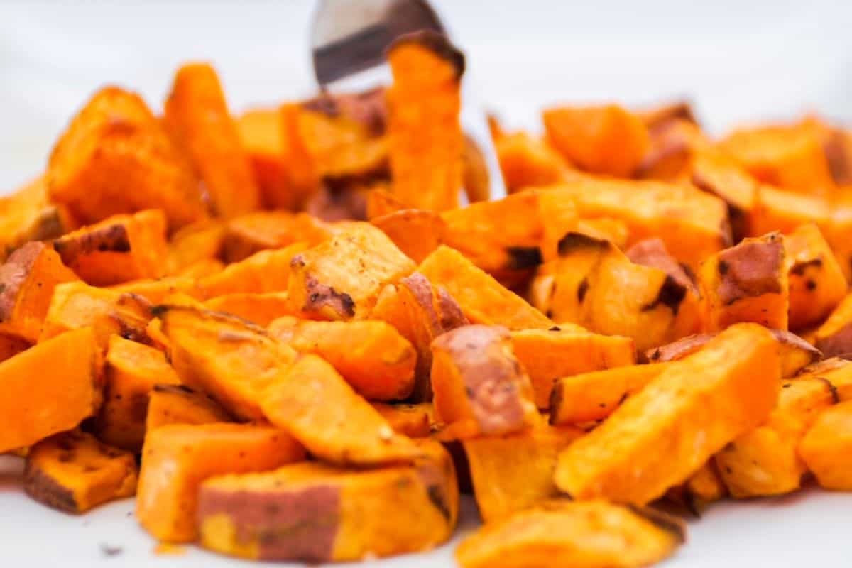 Roasted sweet potato chunks on a white plate.