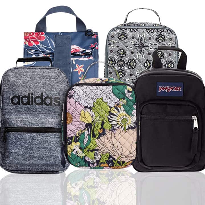 Square image of five lunch boxes for teenagers: one Adidas black and grey lunch box, two Vera Bradley lunch boxes (one with a floral print and another with a black and grey print), one black Jansport backpack style lunch box, and one blue Roxy lunch bag with red floral detail.