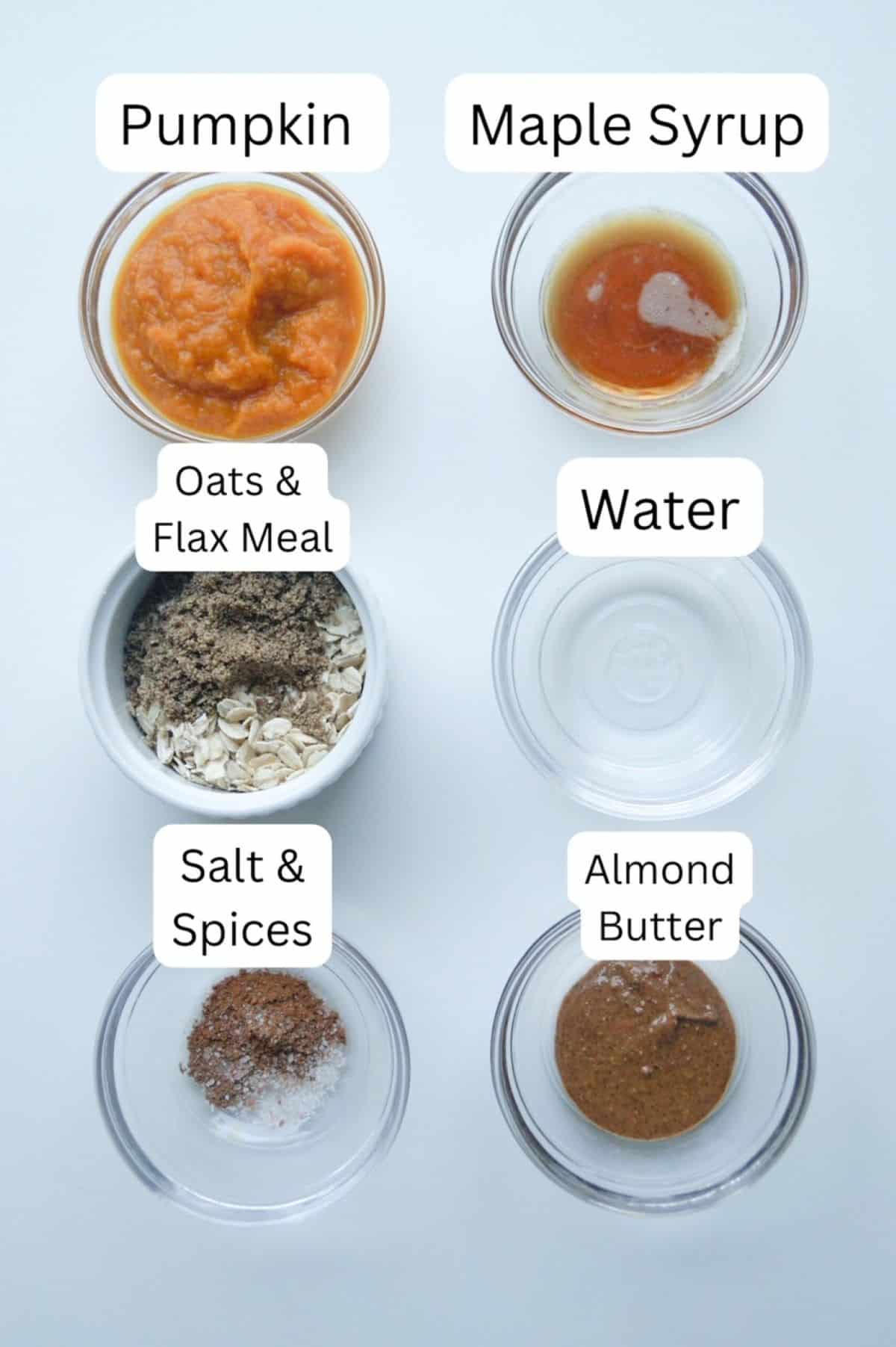 Two vertical rows of small glass prep bowls, labeled: one with pumpkin puree, one with maple syrup, one with oats and flax meal, one with water, one with salt and spices, and one with almond butter.