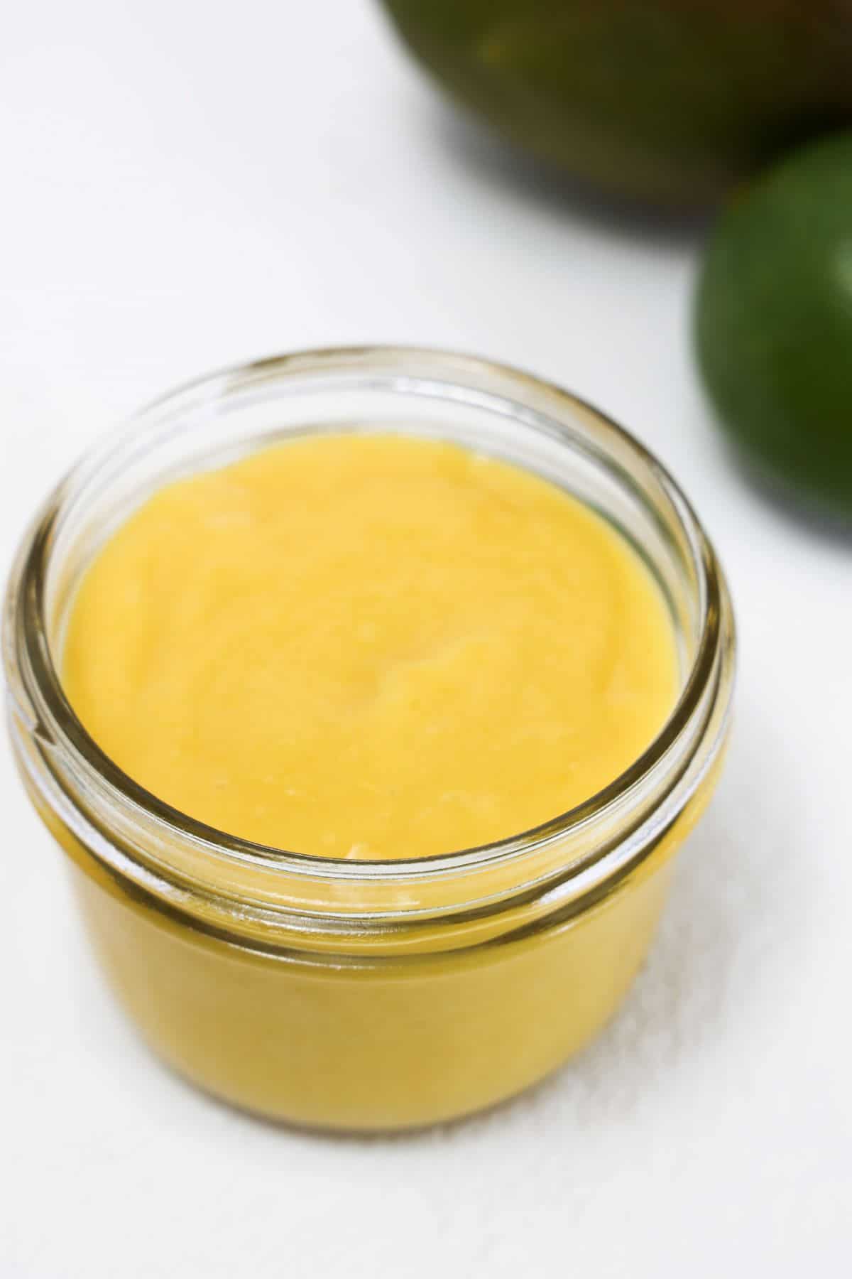 Mango salad dressing in a small glass jar without a lid.