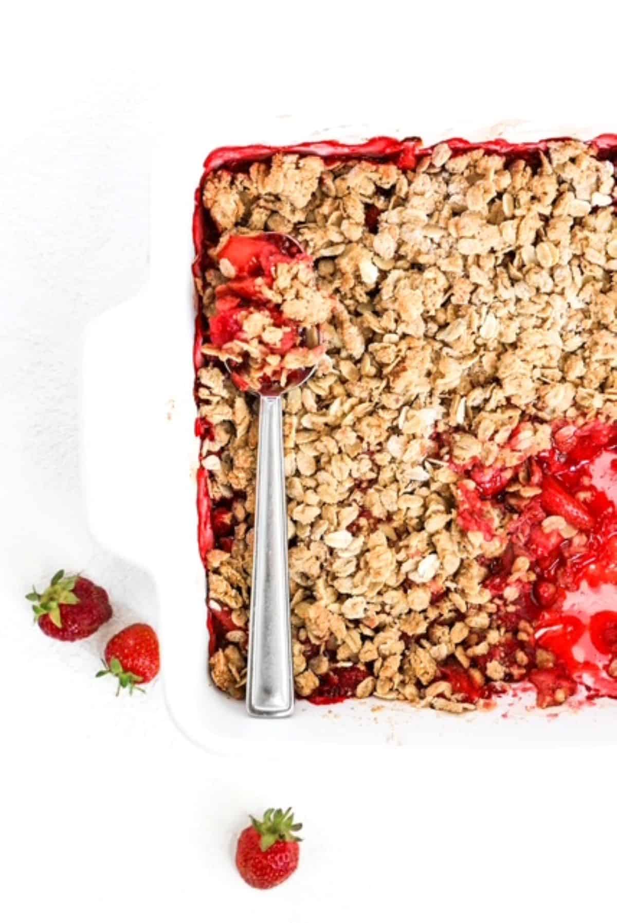 Top view of baked Strawberry Crumble with a serving spoon.