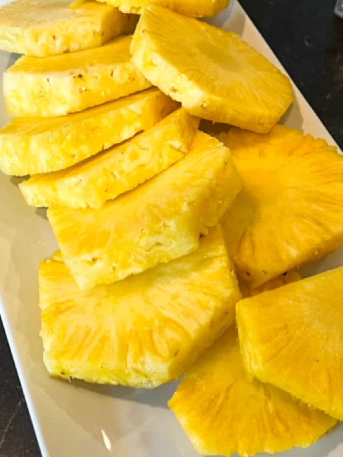 Peeled and sliced pineapple rings with the core still in each ring.