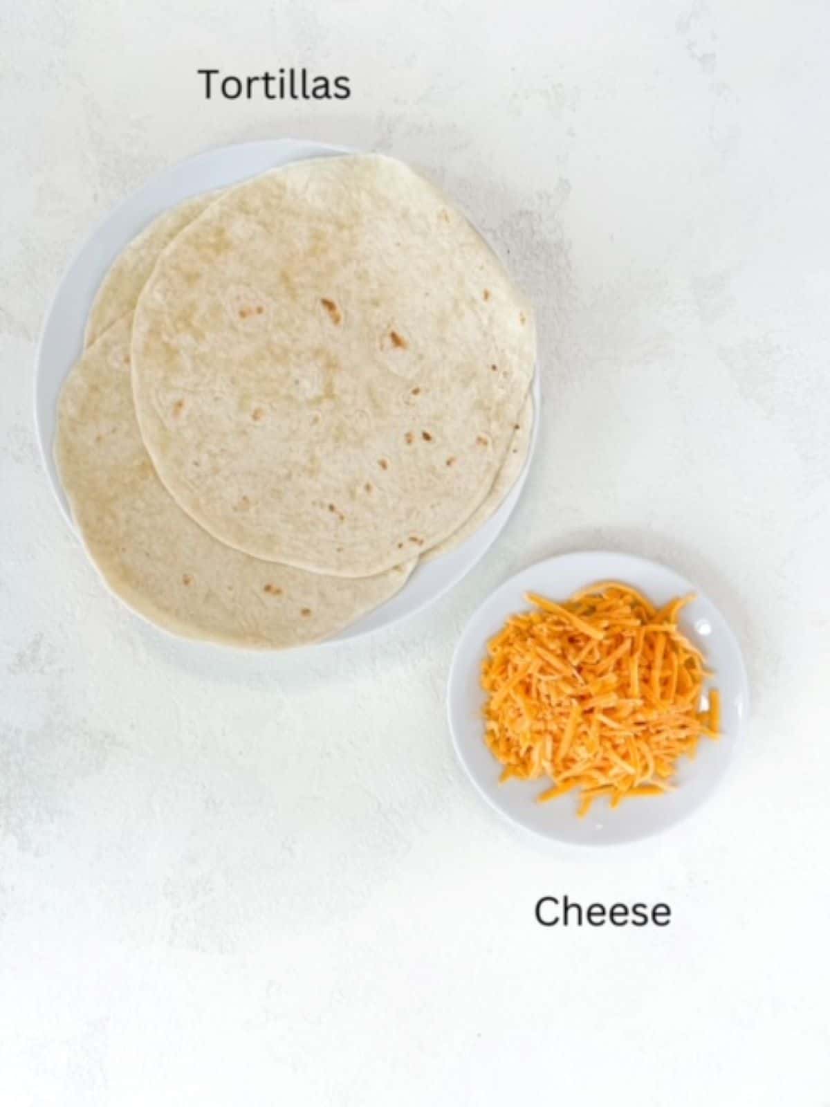 Flour tortillas and shredded cheddar cheese plated separately and labeled.