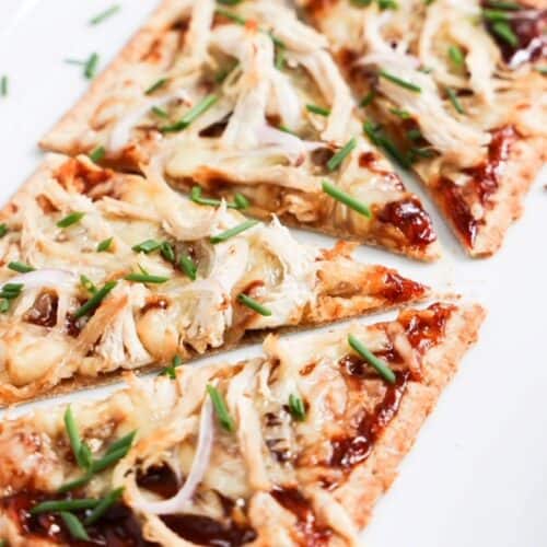 Four slices of BBQ chicken flatbread pizza up close.