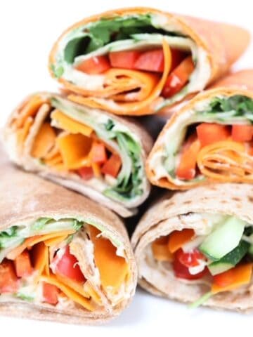 Five halves of hummus veggie wraps stacked together.