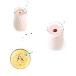 Three different smoothies in glass jars with striped straws.