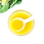 Apple Cider Vinaigrette Dressing in a small glass bowl with a white serving spoon.