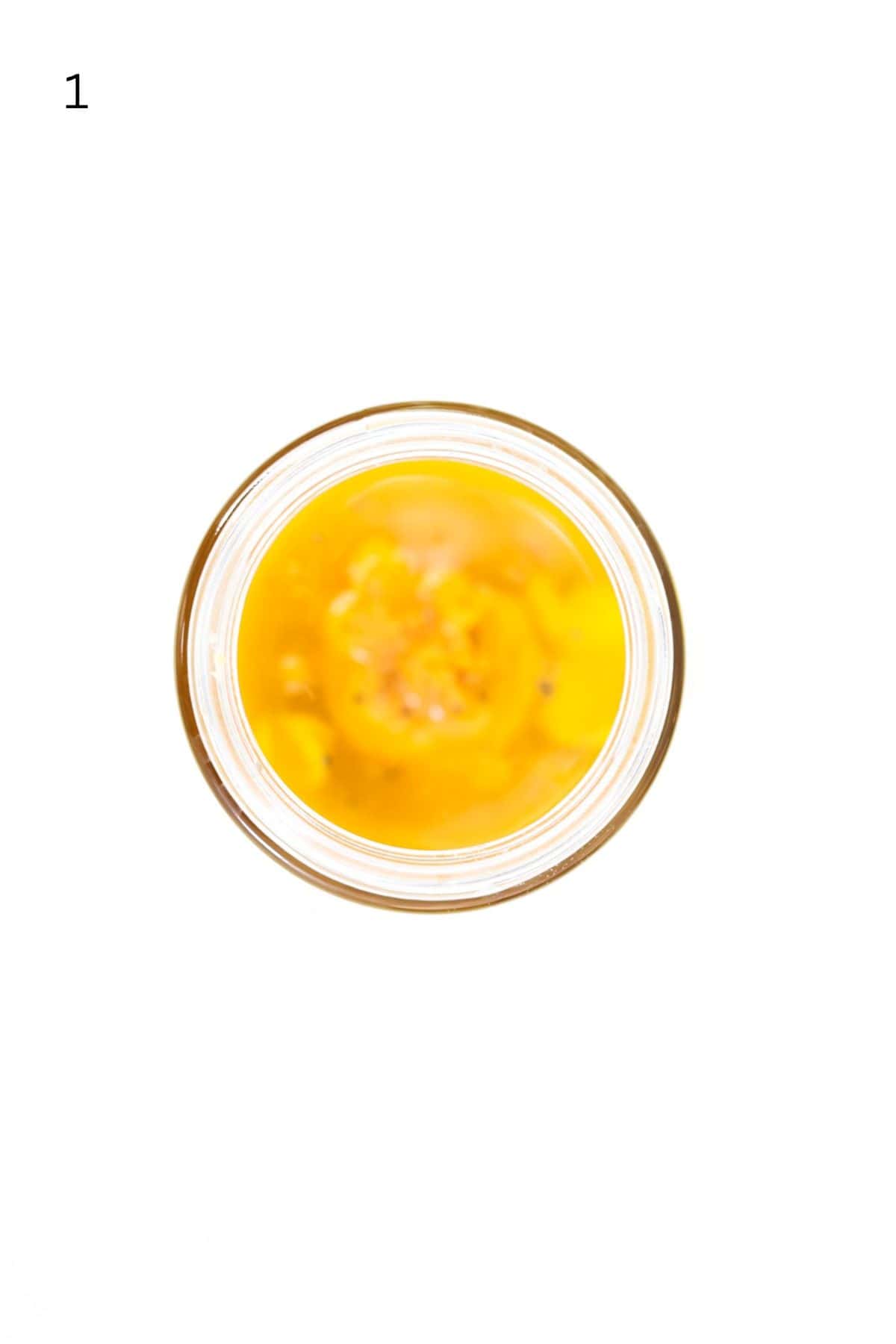 Top view of apple cider vinaigrette dressing ingredients in a jar.
