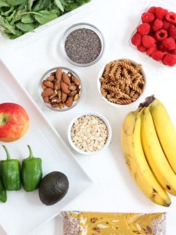 Top view of a variety of high fiber foods on a white board.