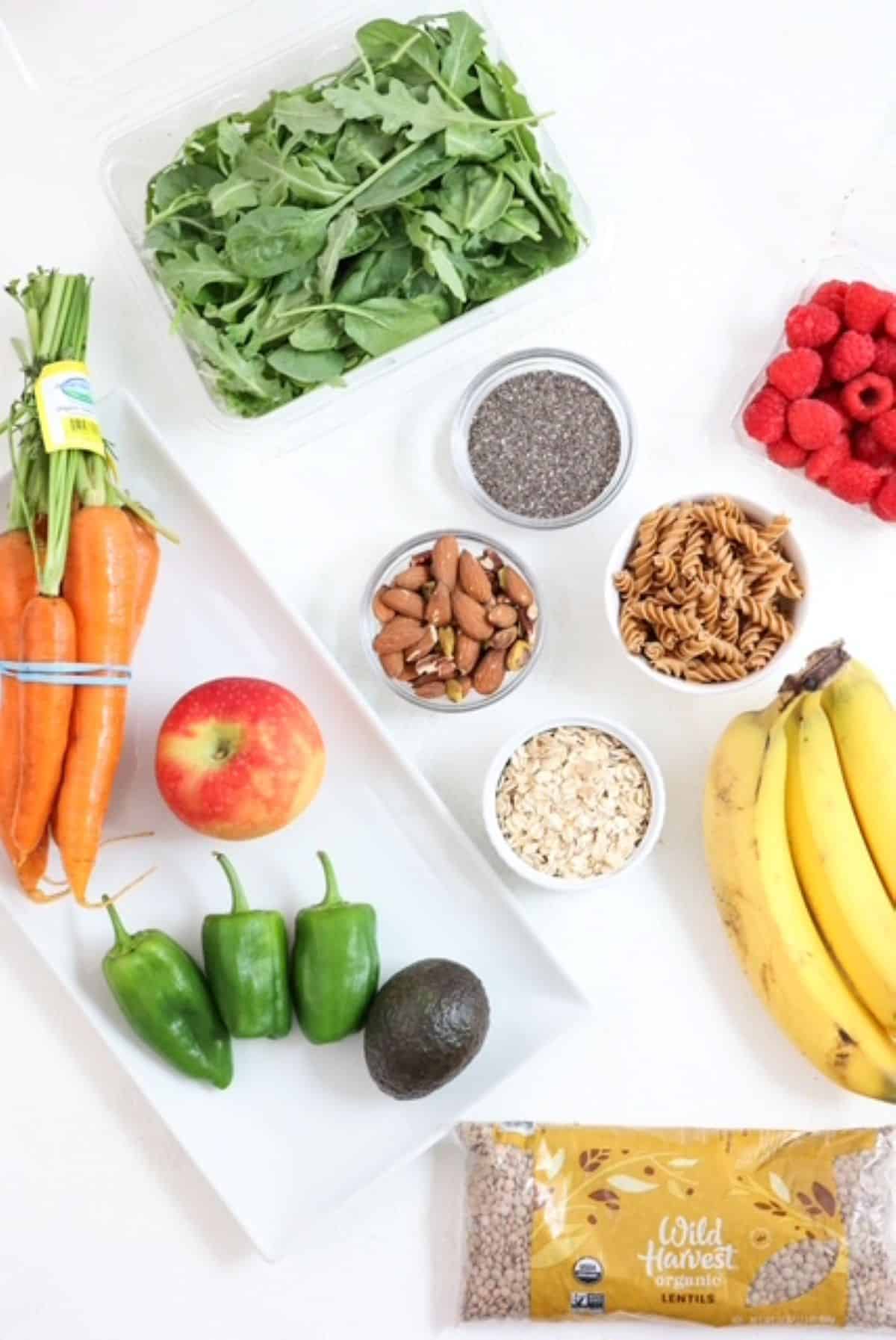 Toop view of a variety of high fiber foods laid out on a white board.