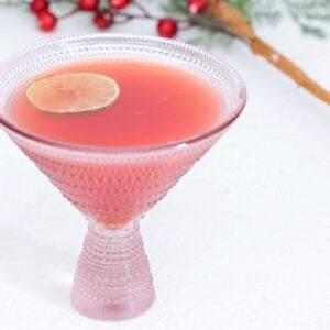 Christmas Holiday Punch in a martini style glass topped with a slice of fresh lime.