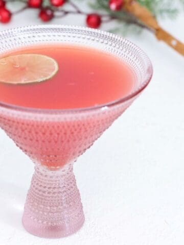 Christmas Holiday Punch in a martini style glass topped with a slice of fresh lime.
