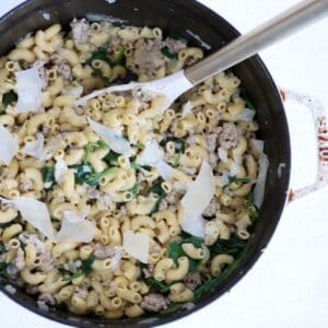 Ground Turkey Pasta dish in a white Staub Dutch oven with a white and gold serving spoon.