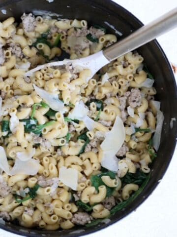 Ground Turkey Pasta dish in a white Staub Dutch oven with a white and gold serving spoon.