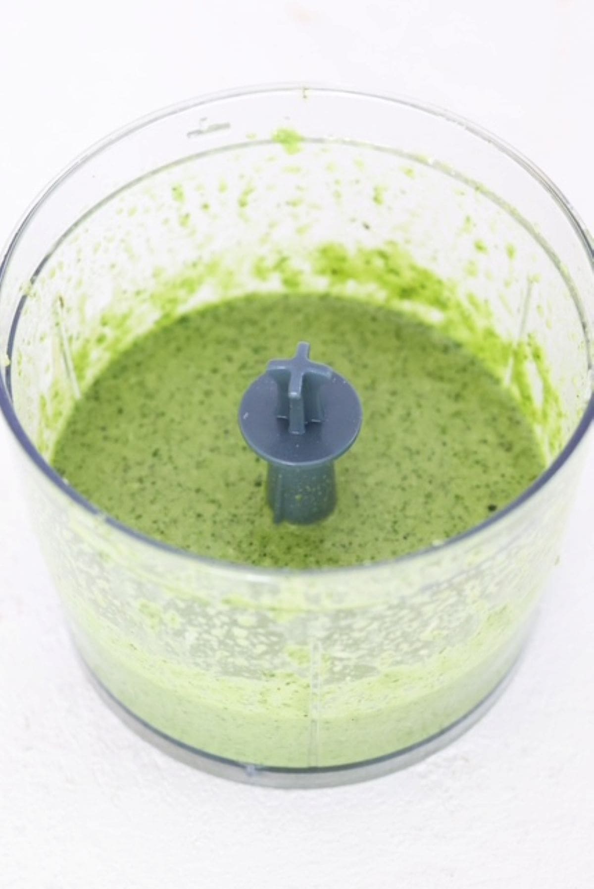 Zucchini pesto in a food processor container.