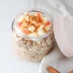 Apple cinnamon overnight oats in a glass jar with the lid to the side.