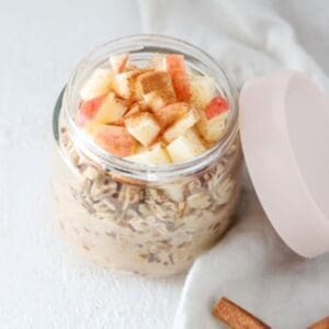 Apple cinnamon overnight oats in a glass jar with the lid to the side.