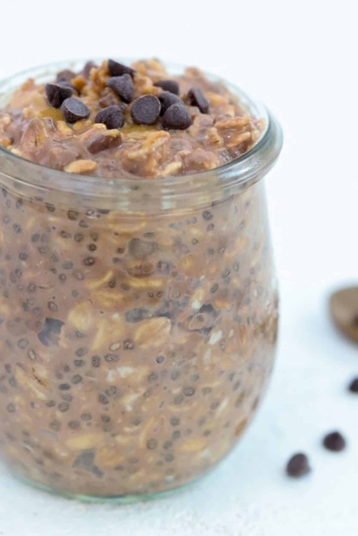Chocolate Peanut Butter Overnight Oats in a tulip shaped glass jar topped with mini chocolate chips.