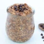 Chocolate peanut butter overnight oats topped with mini chocolate chips in a glass jar.