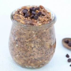 Chocolate peanut butter overnight oats topped with mini chocolate chips in a glass jar.