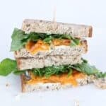 Two halves of a goat cheese sandwich stacked on top of each other.