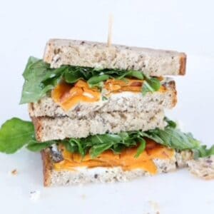 Two halves of a goat cheese sandwich stacked on top of each other.