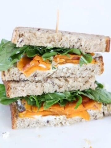 Two halves of a goat cheese sandwich stacked on top of each other.